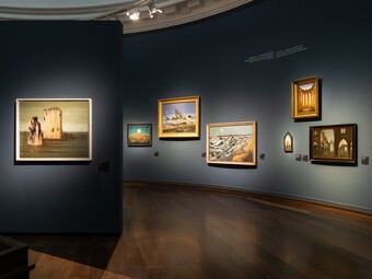Installationsansicht der Ausstellung RENDEZVOUS DER TRÄUME. Surrealismus und deutsche Romantik, 13. Juni bis 12. Oktober 2025, v.l. mit den Werken Blick auf Schloß Pillnitz, 1823, von Johann Christian Dahl, 1) Der Hausengel und 2) Der Hausengel (Der Triumph des Surrealismus), beide 1937, von Max Ernst, Königin Mab, 1814, von Johann Heinrich Füssli, Die Unsichtbaren – Schlafende, Pferd, Löwe, 1930, von Salvador Dalí und Caspar David Friedrich in seinem Atelier, 1811, von Georg Friedrich Kersting