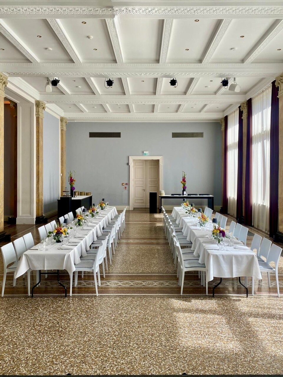 Eleganter Veranstaltungssaal mit weißen Tischen