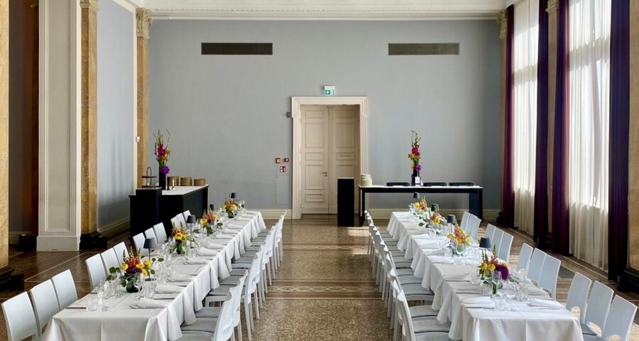 Eleganter Veranstaltungssaal mit weißen Tischen